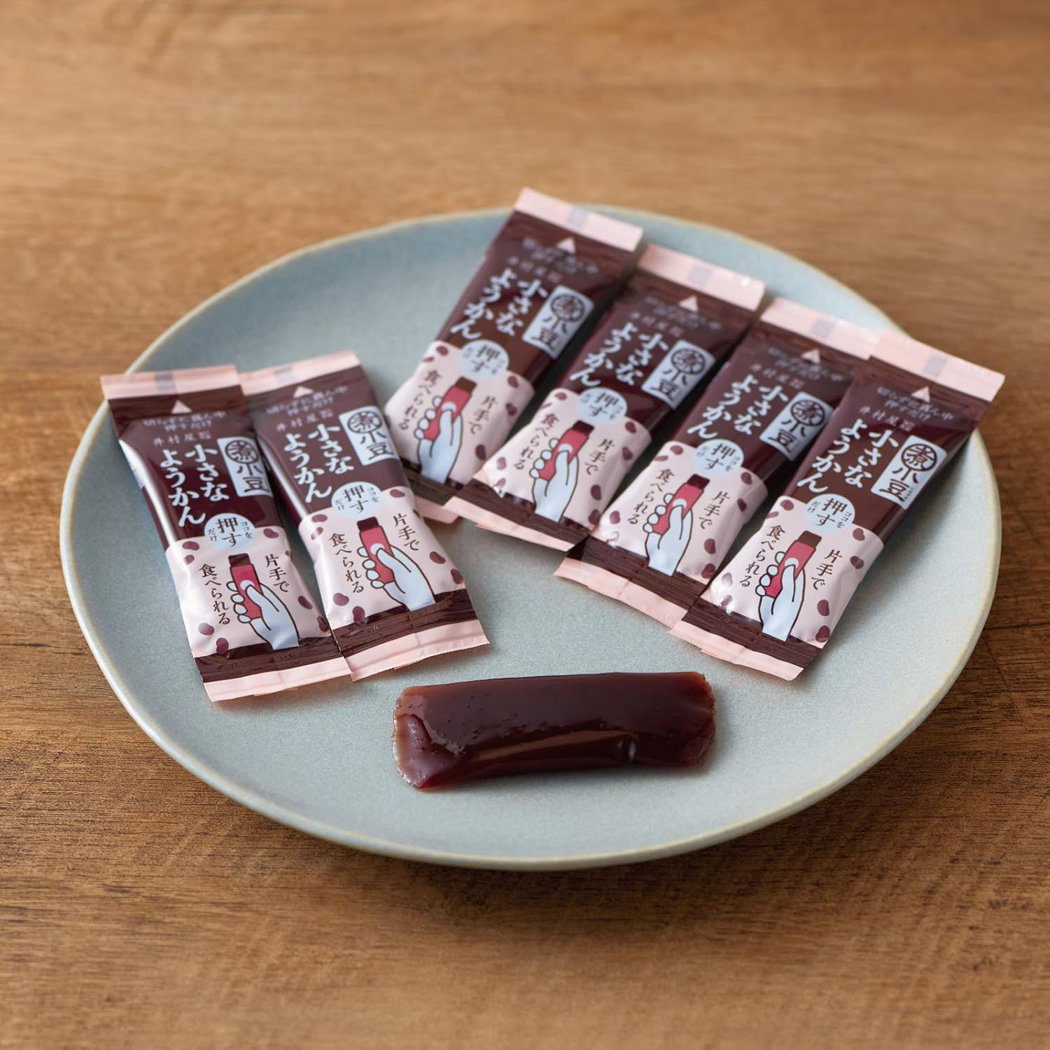 Close-up of a person squeezing a mess-free Imuraya single-serve red bean jelly stick using one hand.