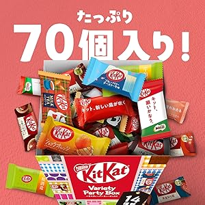 Hands opening the Nestle Japan KitKat 70-piece gift box to reveal a massive assortment of vibrant, individually wrapped chocolate bars.